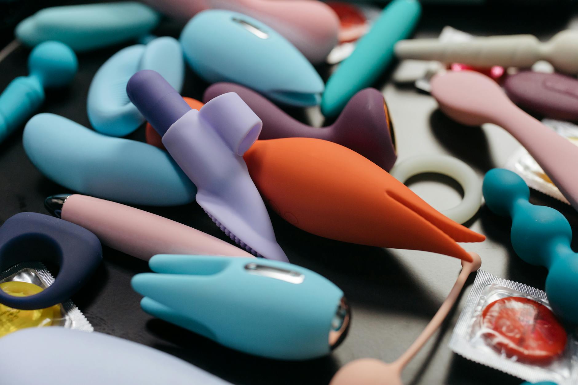 Close-up arrangement of colorful clitoral vibrators and lemon-shaped suction toys on a neutral surface