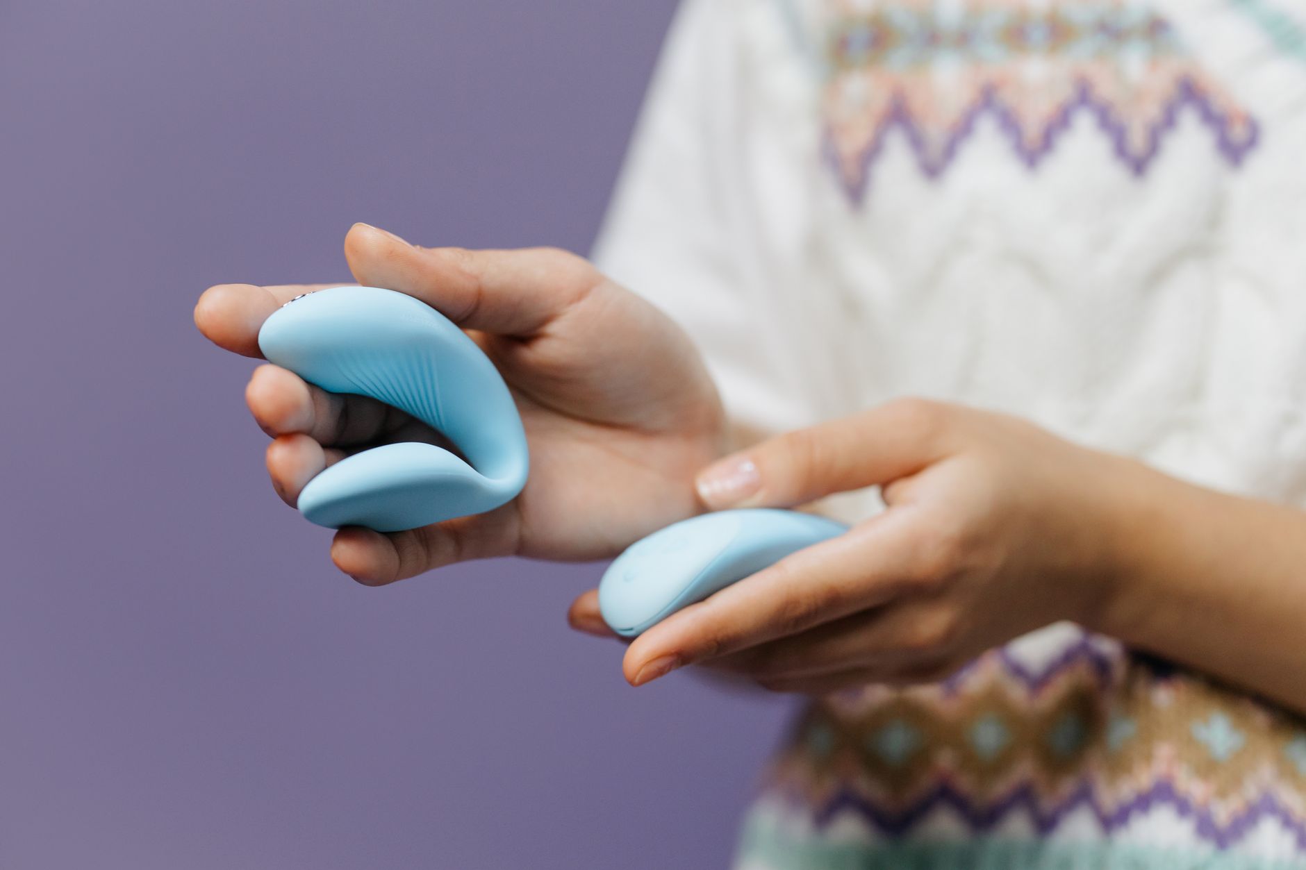 Pareja joven sosteniendo un vibrador azul, simbolizando la intimidad moderna.