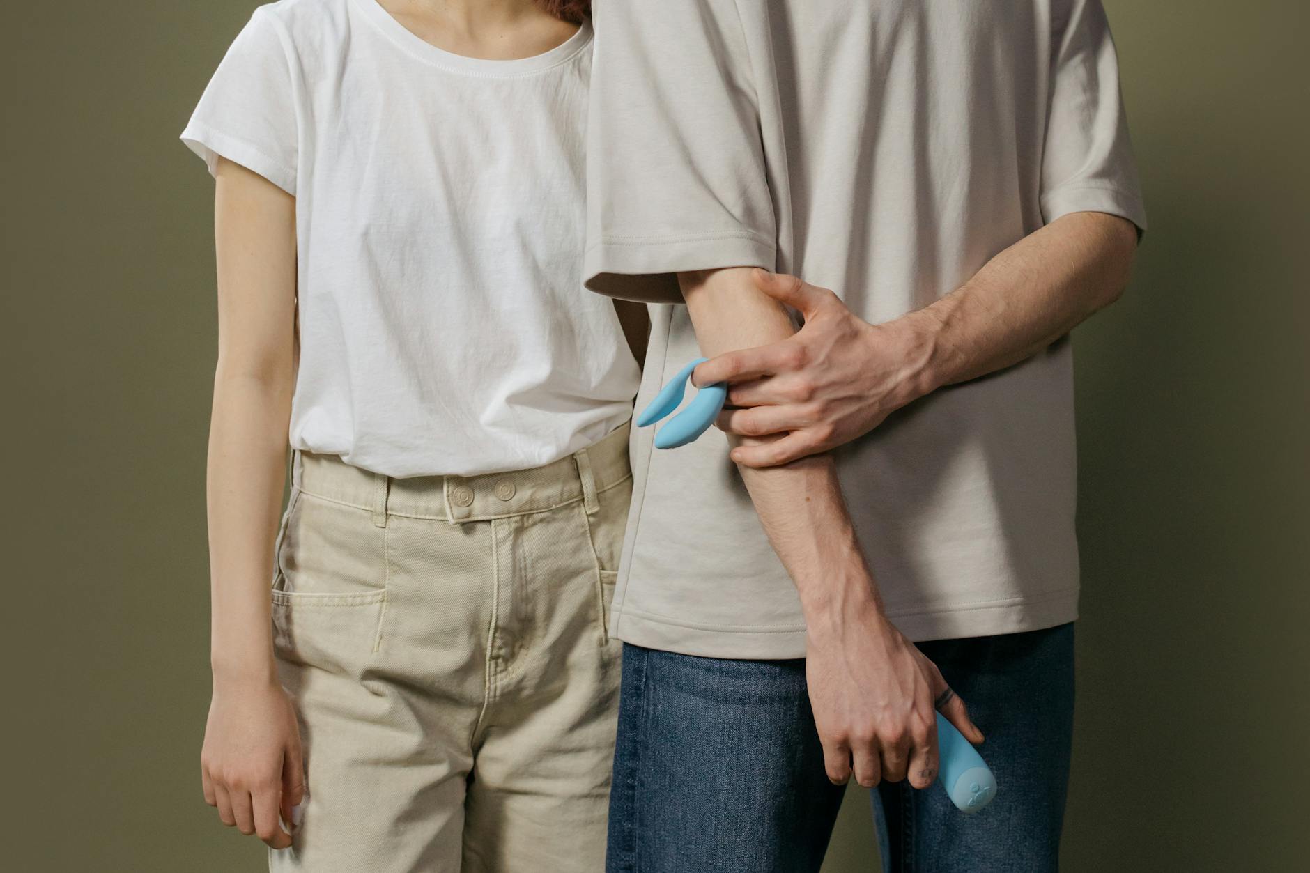 A young couple standing together indoors, exploring intimate pleasure with a modern vibrator
