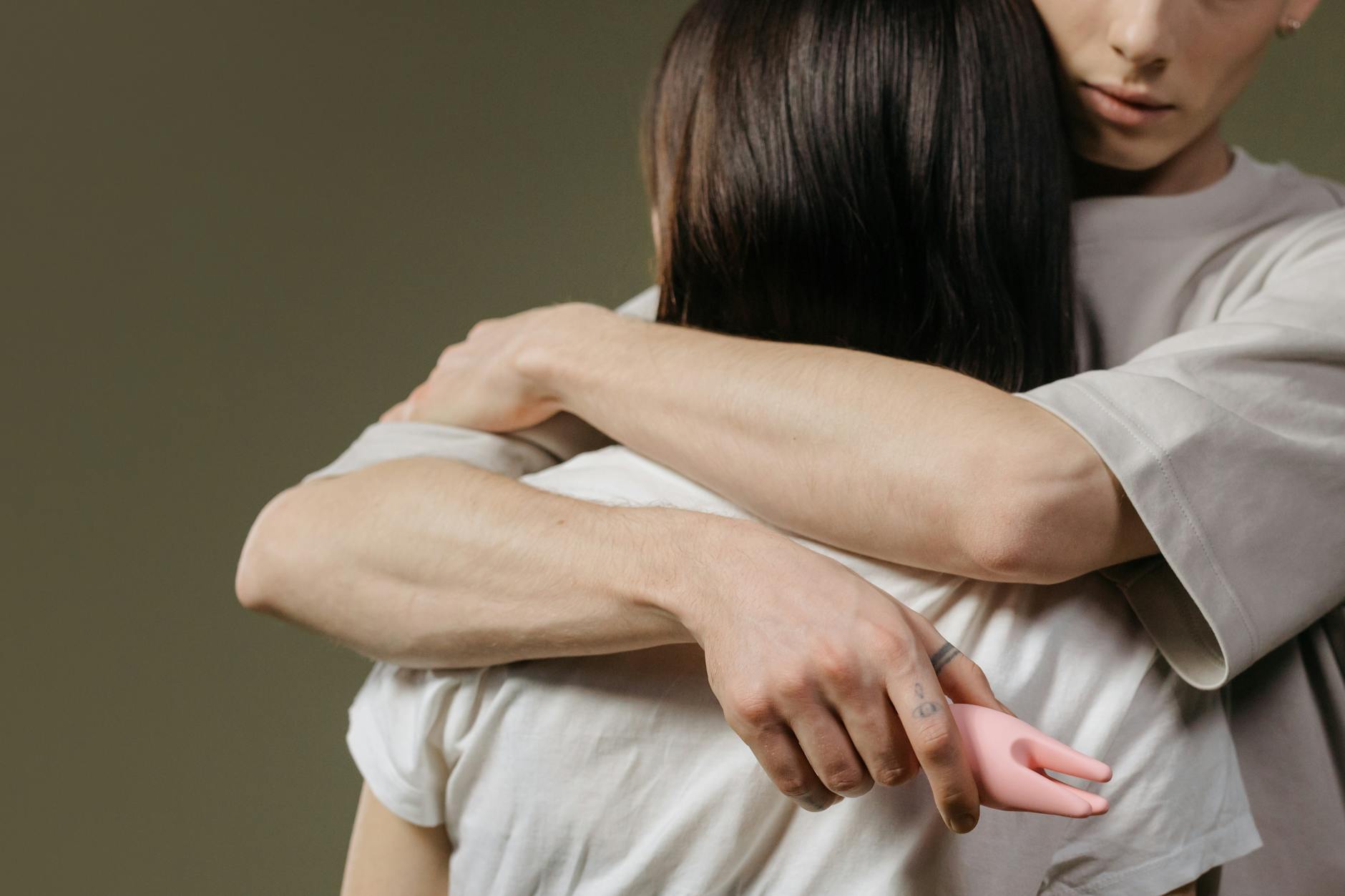 Una pareja joven abrazándose en la intimidad, destacando la conexión y la confianza.