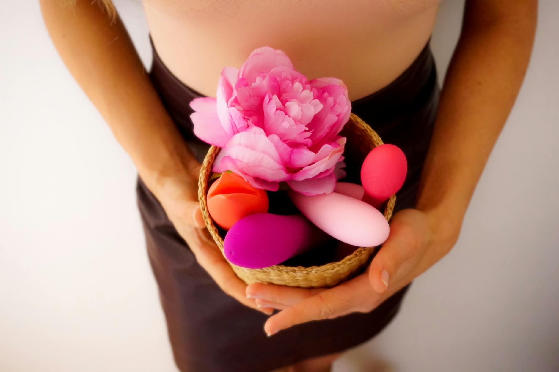 Colorful vibrators and wellness items in a basket, representing relationship intimacy tools