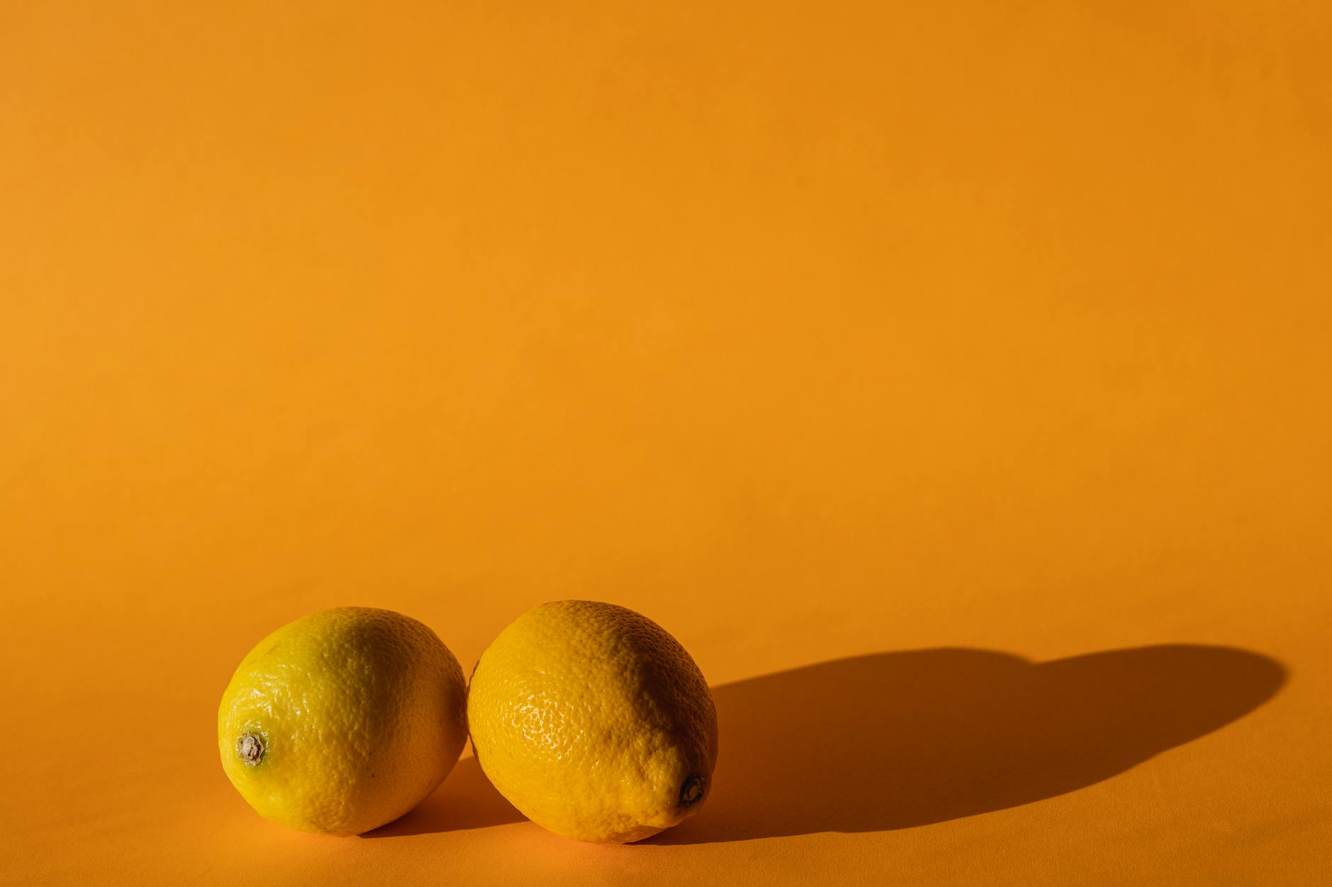 Bright vivid lemons on a yellow background representing fresh sensations and pleasure discovery